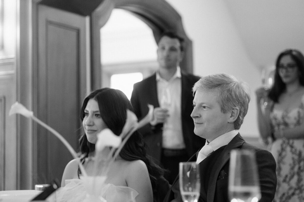 Black and white photo of a bride and groom during their reception speeches