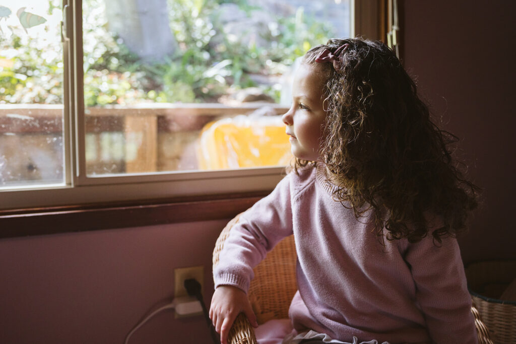 Little girl looking out a window