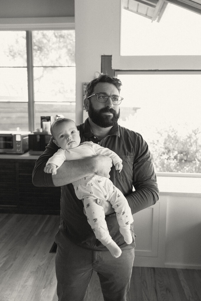 Black and white photo of a father holding his newborn daughter