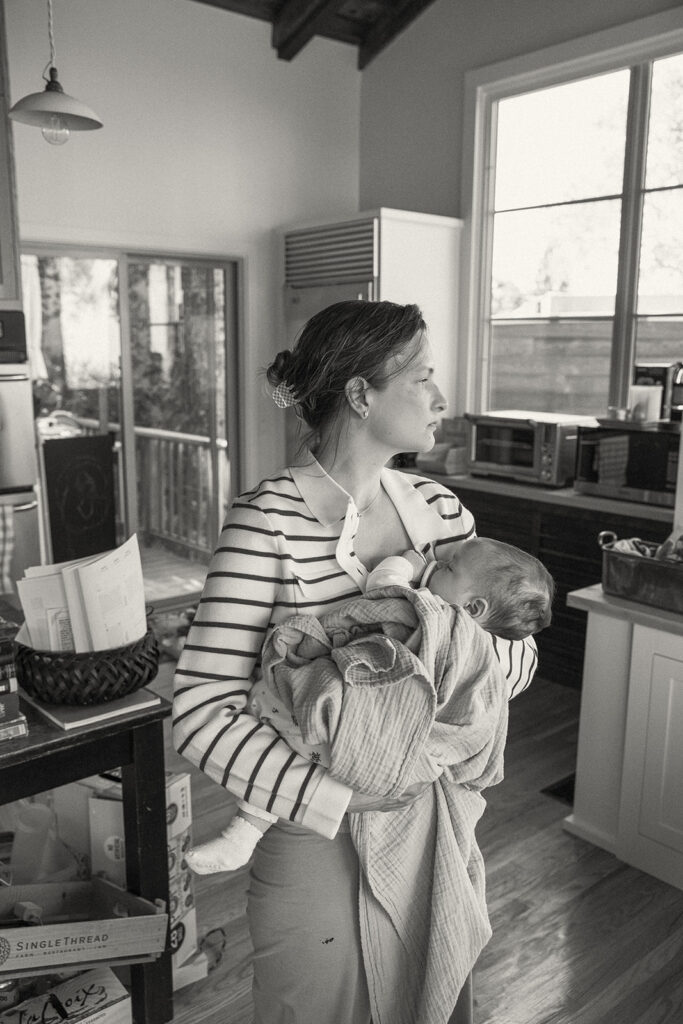 Black and white photo of a mother holding her newborn during their at-home newborn photos in Berkeley, California