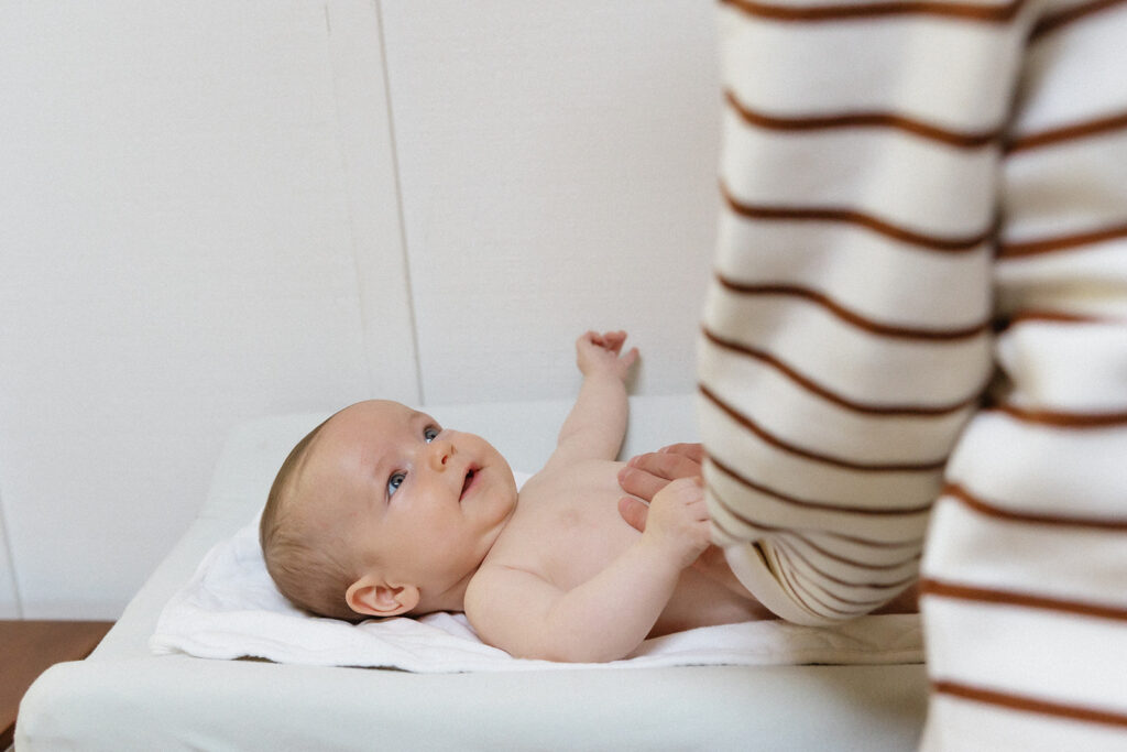 Mother changing her newborn baby during their candid at-home newborn photos in Berkeley, California