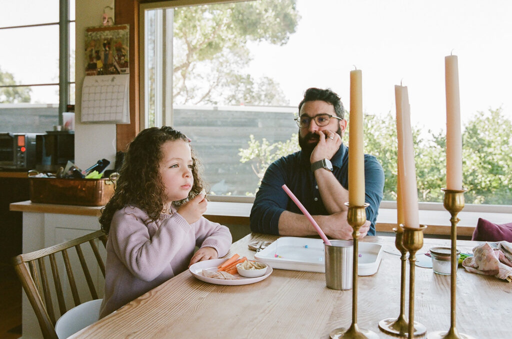 Father watching his daughter as she has snacks