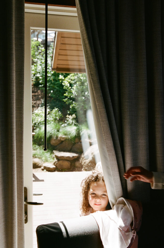 Little girl hiding behind a curtain