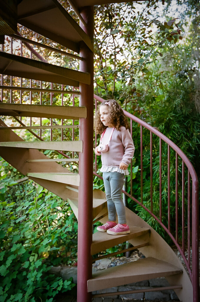 Little girl going up a spiral staircase