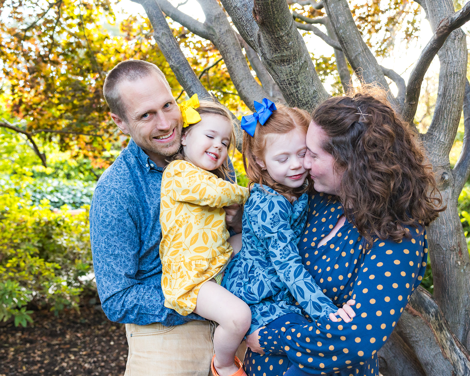 Family of four posing for photos at the park