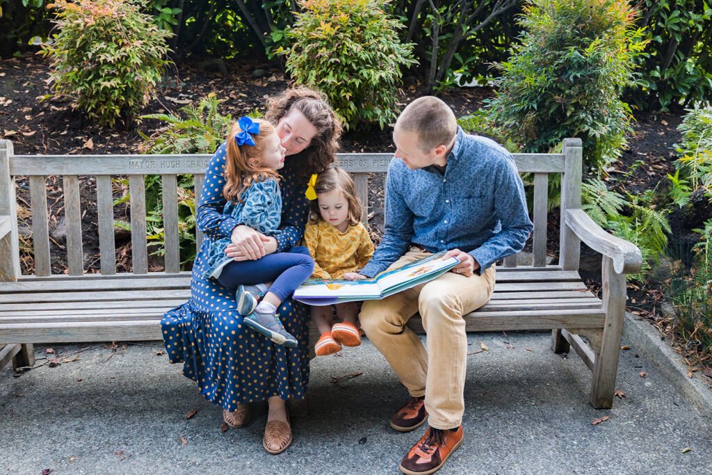 Family sitting on a bench during their outdoor family session at Piedmont Parlkin the East Bay of California