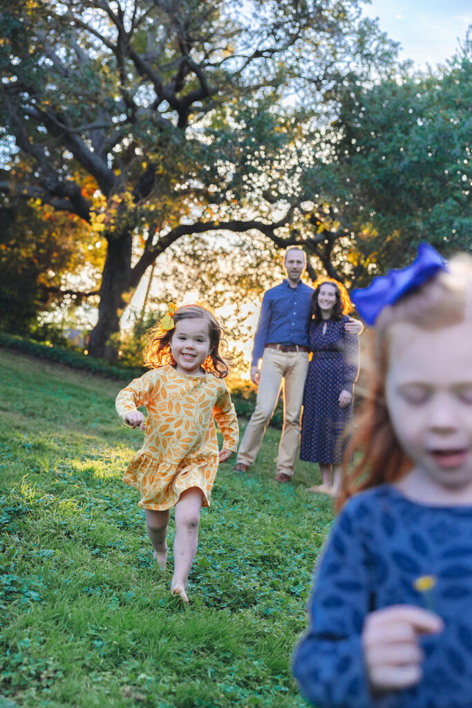 Little girls running towards the camera with dandelions that they picked