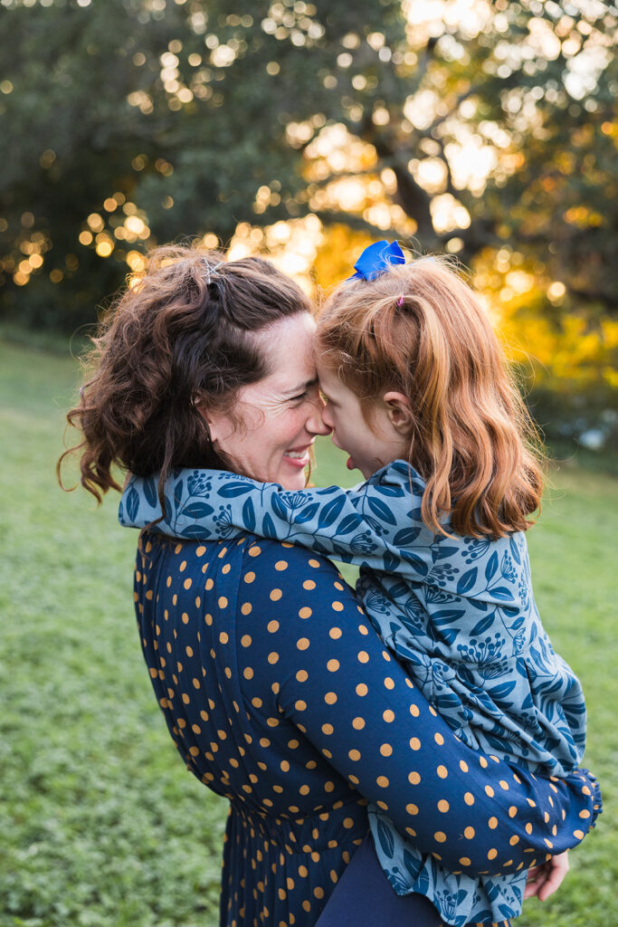 Mother holding her daughter and touching noses