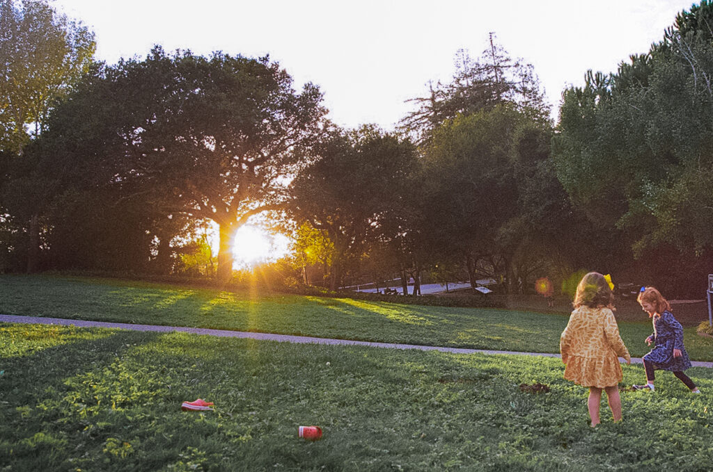 Little girls playing during their outdoor Piedmont Park family photos in the East Bay of California