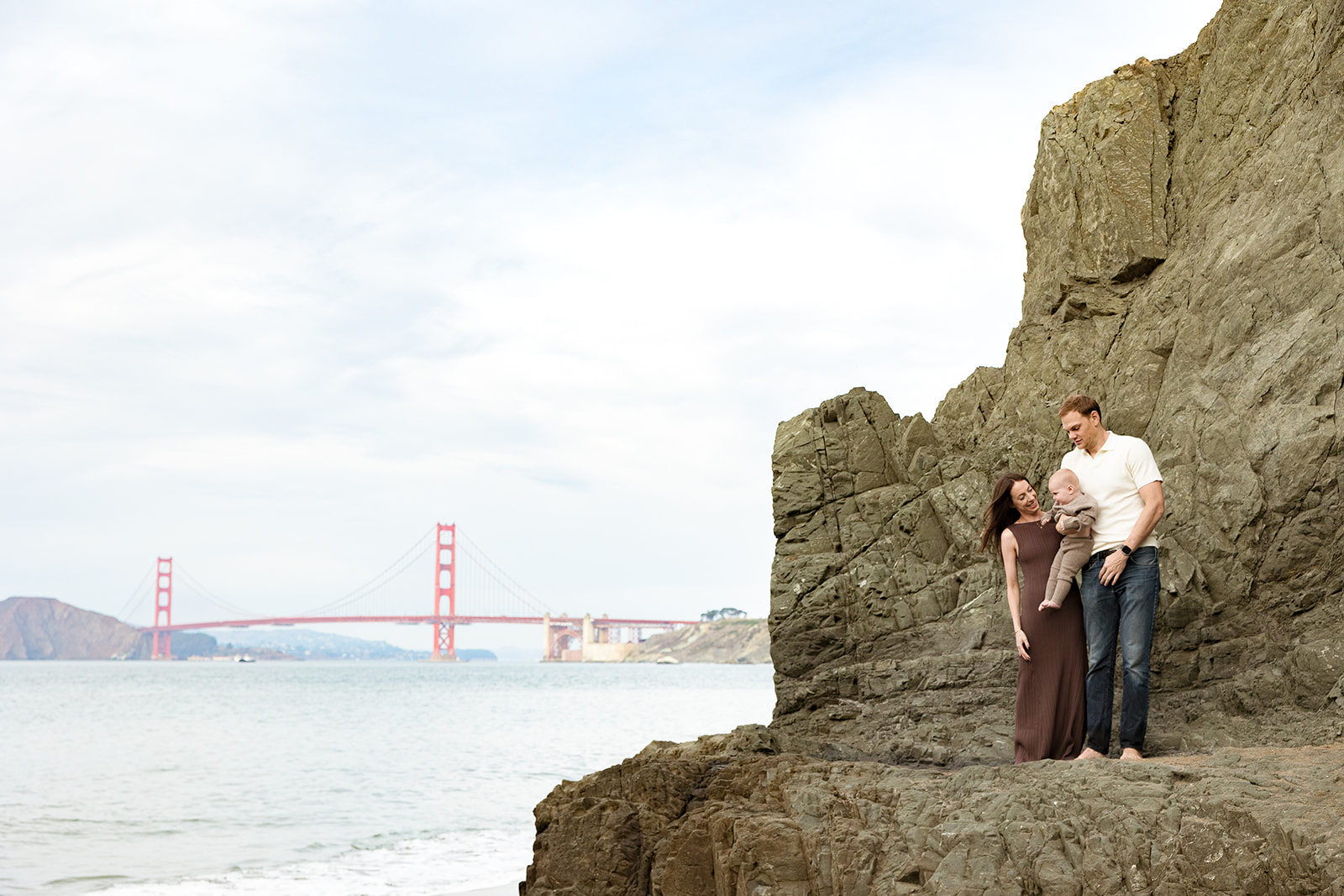 Family of three posing for their Bay Area Family photos on China Beach