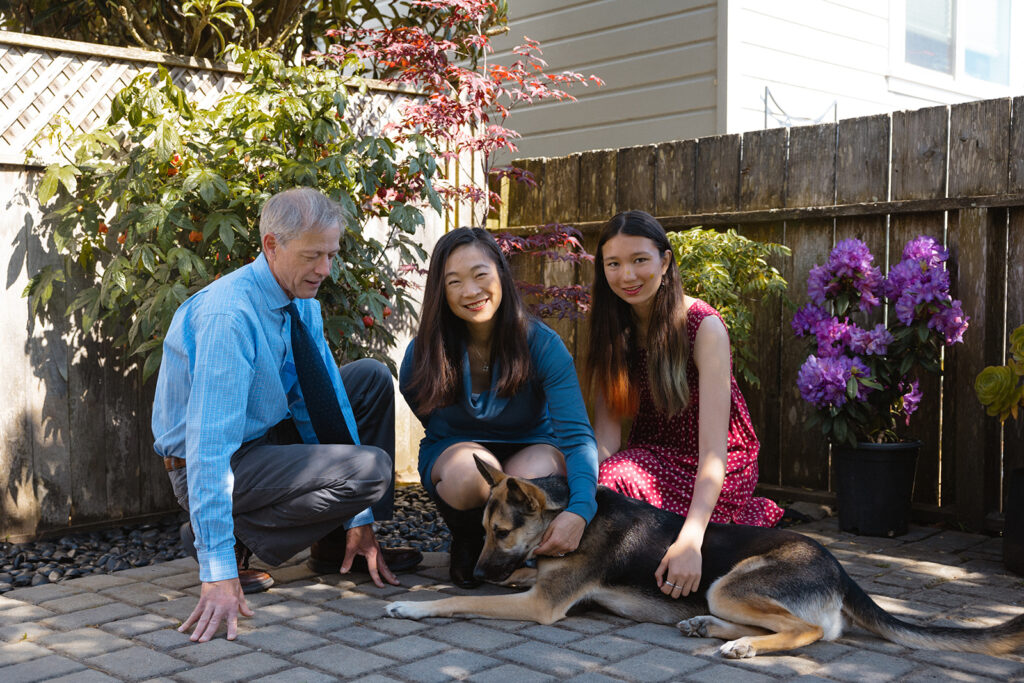 Family of three petting their dog during their at-home family photos in San Francisco, California