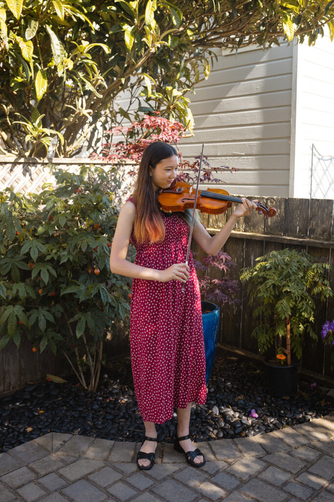 Girl playing her violin in her backyard in San Francisco, California