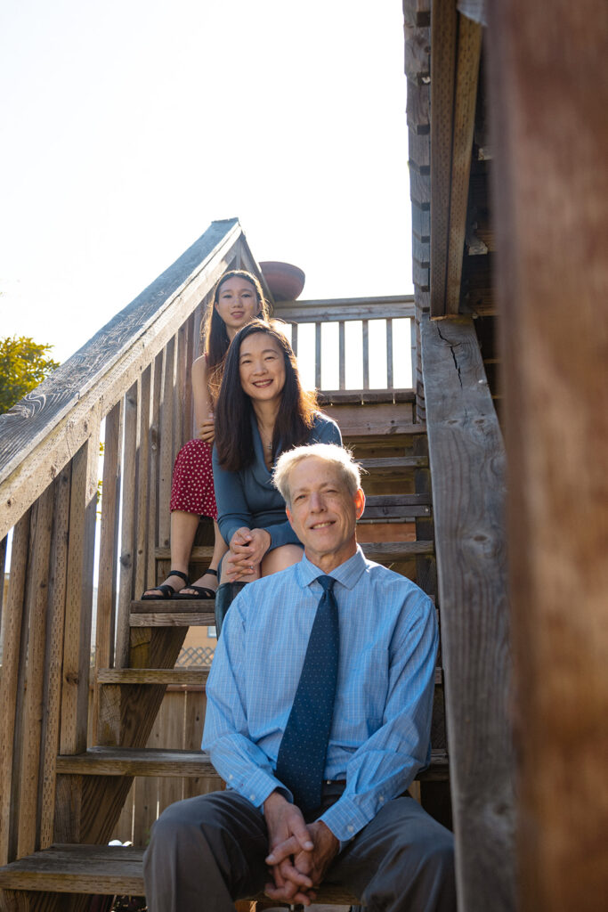 Family of three sitting on their stairs for their at-home family photos in San Francisco