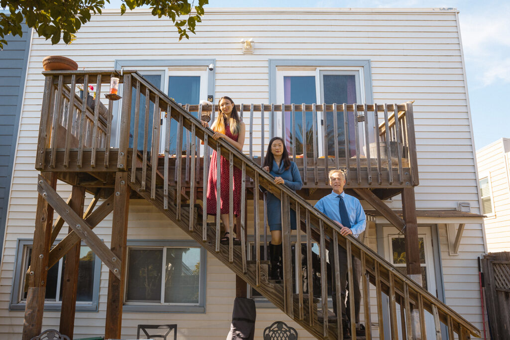 Family of posing on their stairs for their at-home family photos in San Francisco