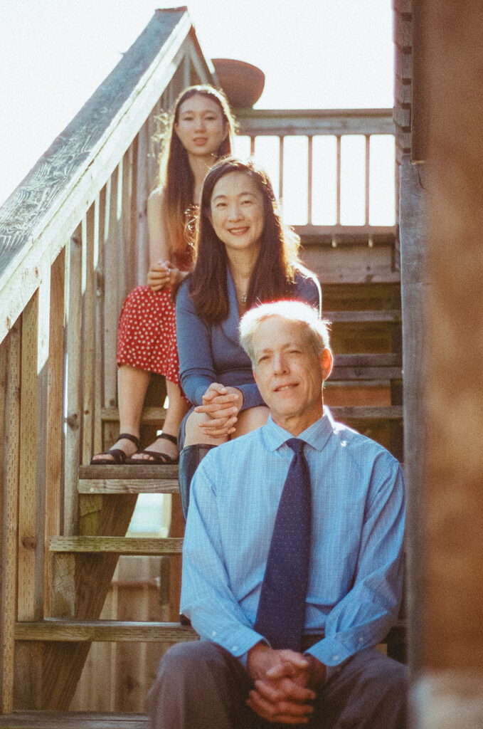 Family of three sitting on their backyard stairs for their at-home family photos in San Francisco captured on film