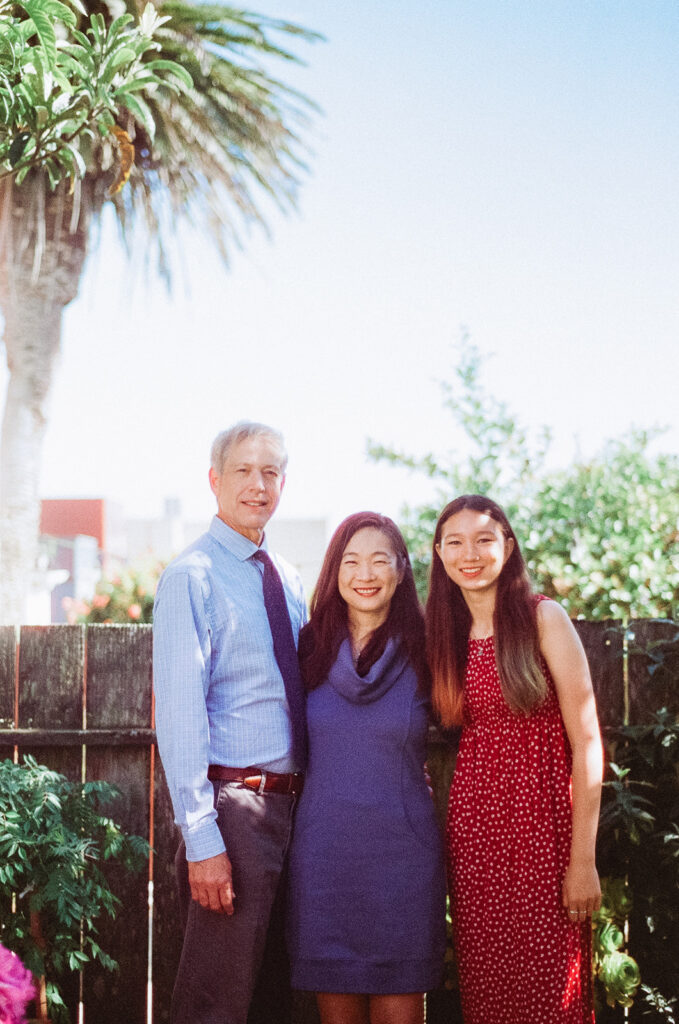 Family of three posing in their backyard for their at-home family photos in San Francisco captured on film