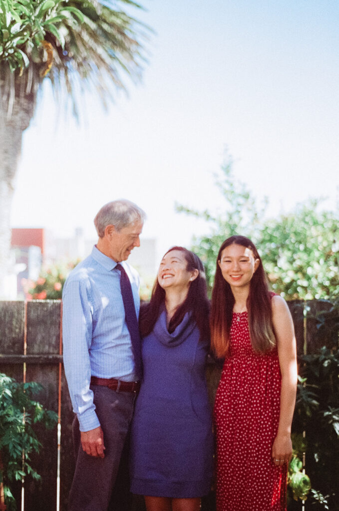 Family of three posing in their backyard for their at-home family photos in San Francisco captured on film