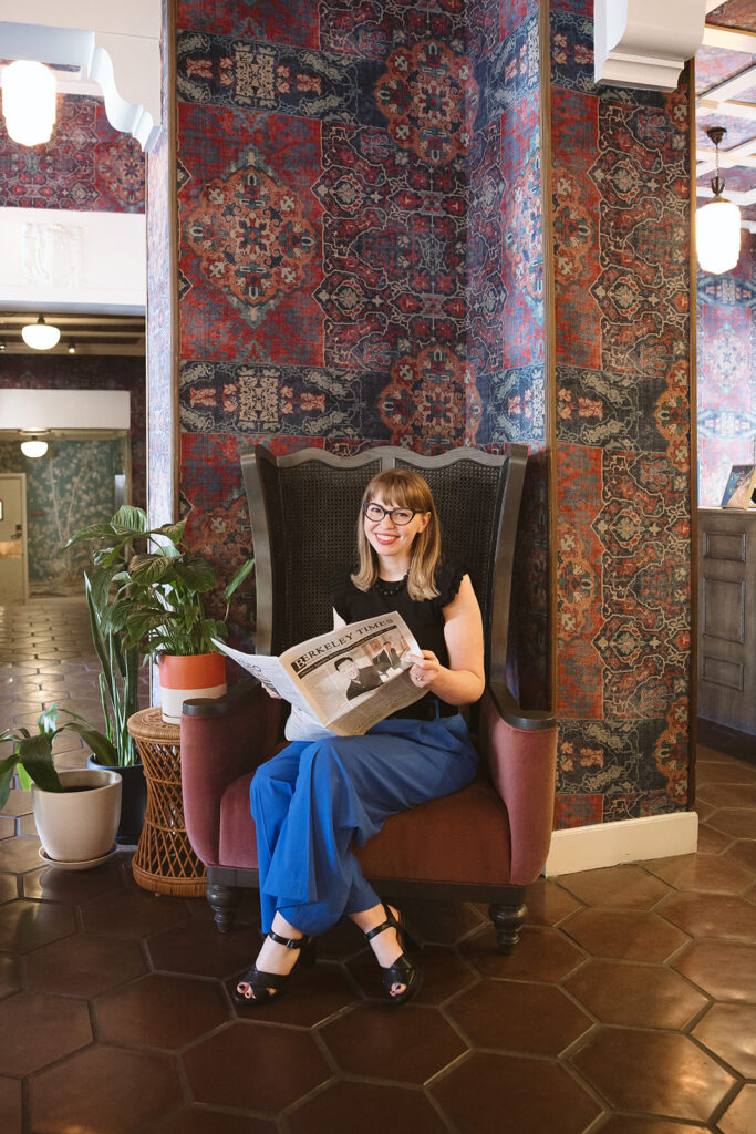 Woman sitting in a chair with a Berkeley newspaper