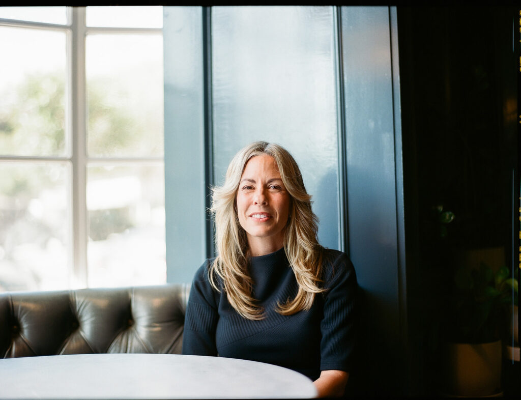 Woman sitting at a table for her branding photos captured on film