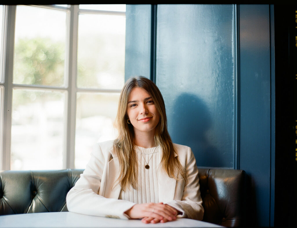 Woman sitting at a table for her branding photos captured on film