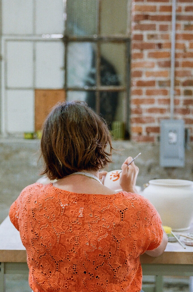 Woman painting her pottery