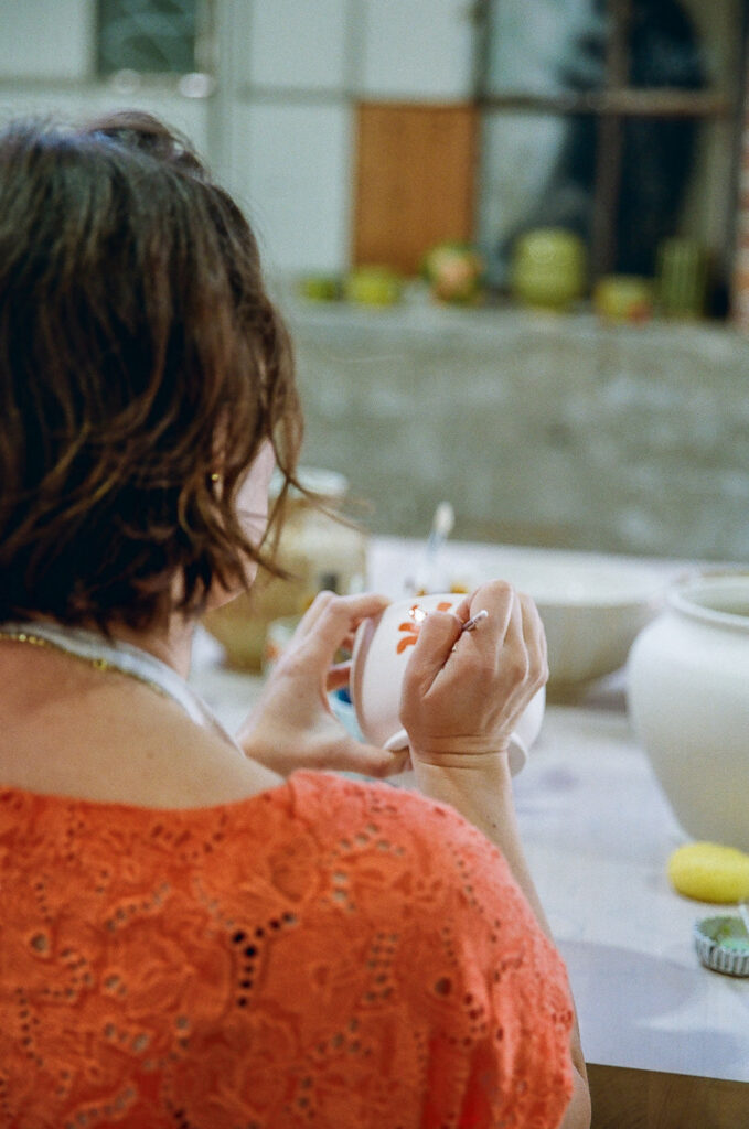 Woman painting her pottery