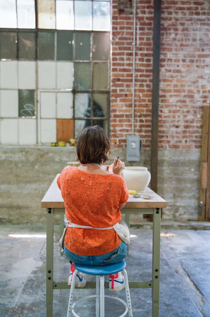 Woman painting her pottery