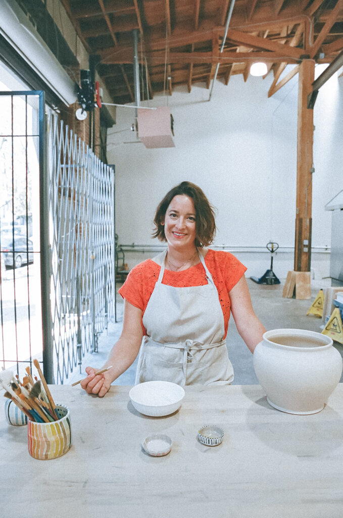 Woman painting her pottery bowl