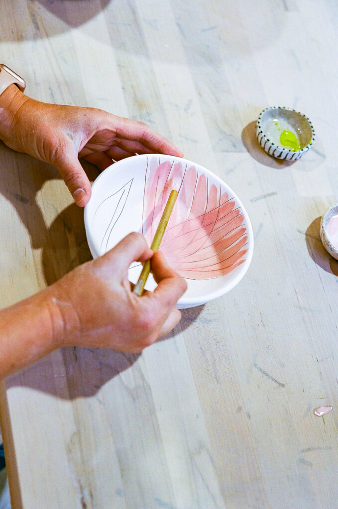 Woman painting her pottery bowl