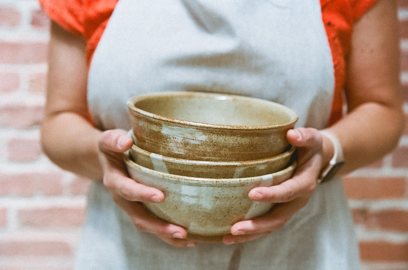 Woman holding a stack of bowls for her creative branding session on film for The Pottery Studio San Francisco