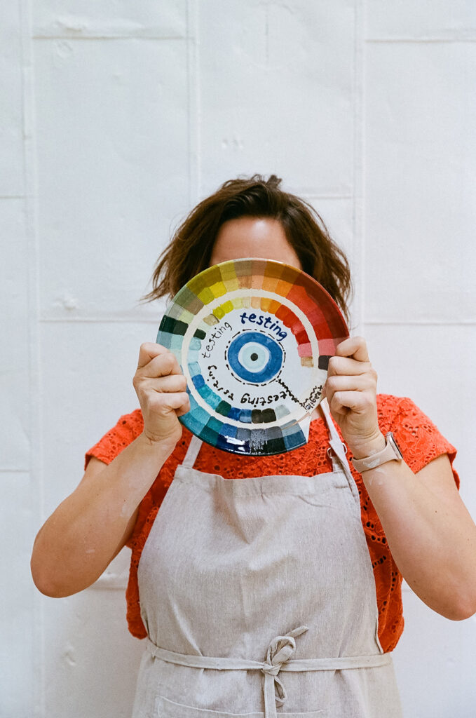 Woman holding up a colorful wheel for her creative film branding photography for The Pottery Studio San Francisco