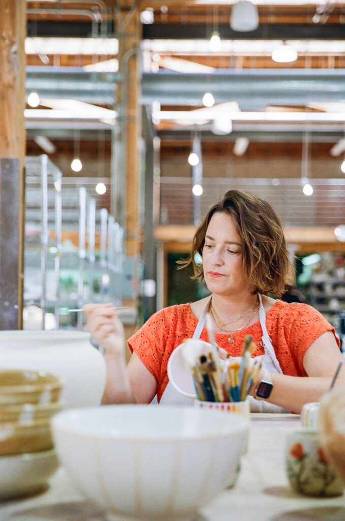 Woman painting her pottery