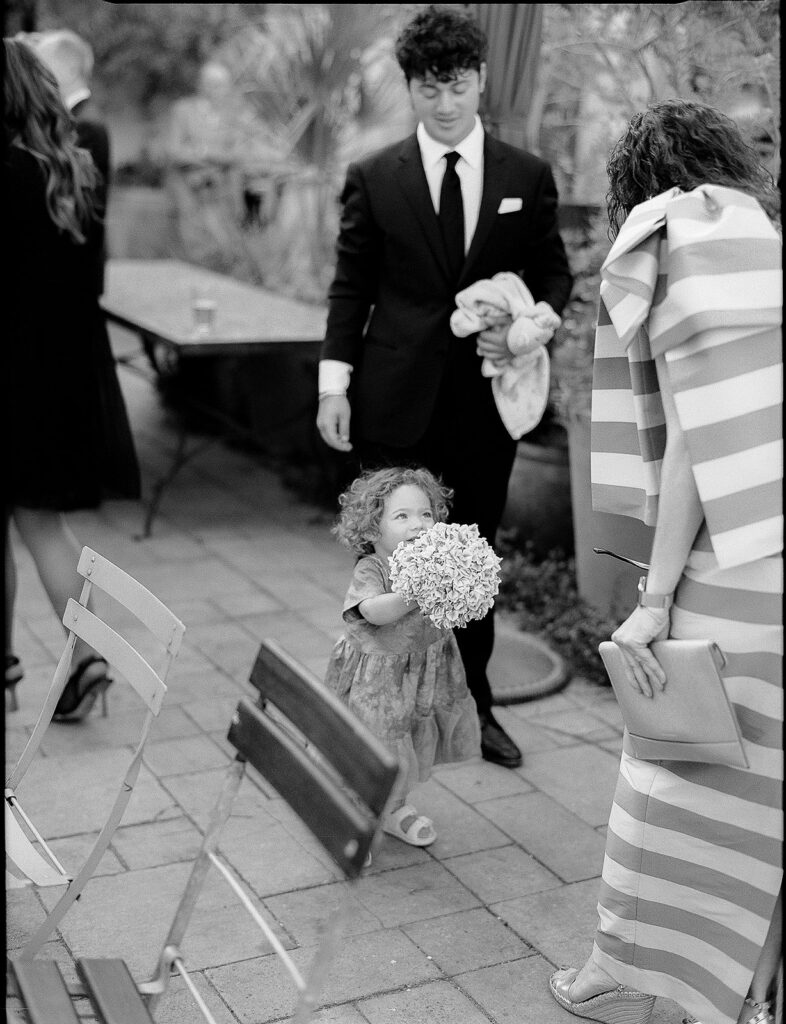 Black and white photo of a little girl running with flowers