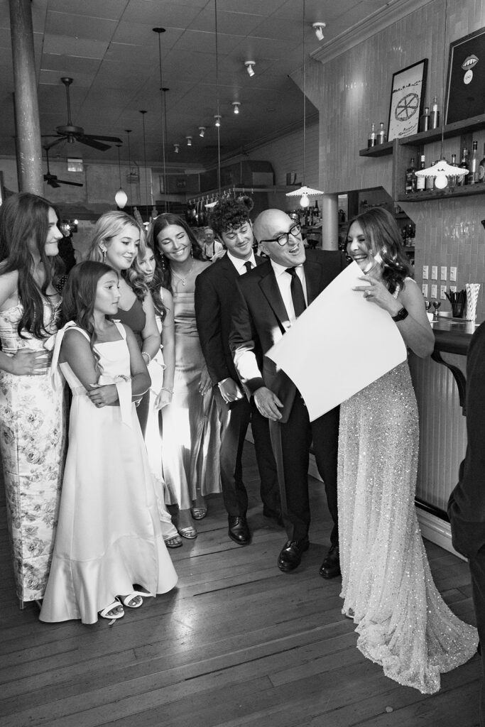 Black and white photo of a bride and groom signing their marriage certificate