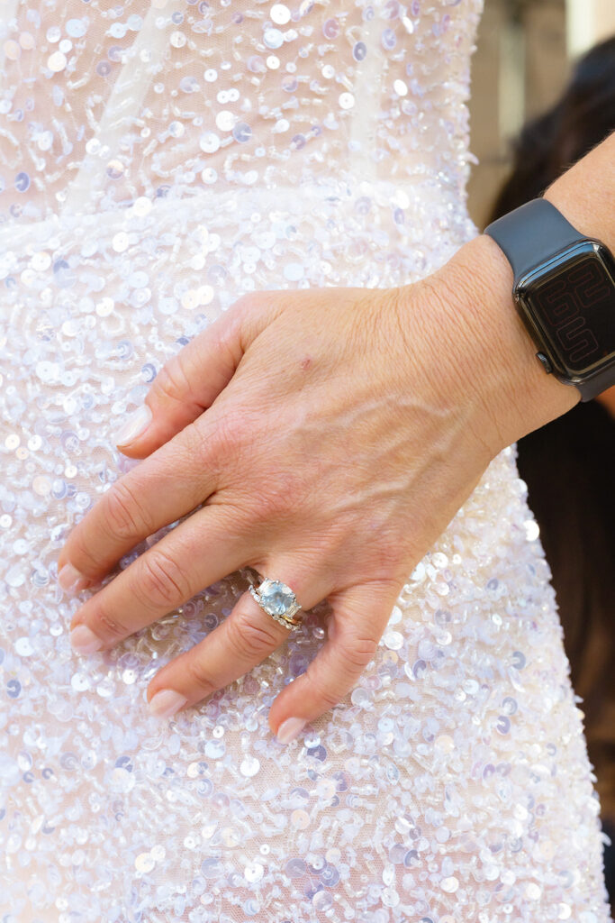 Close up photo of a bride wearing her wedding dress and wedding ring