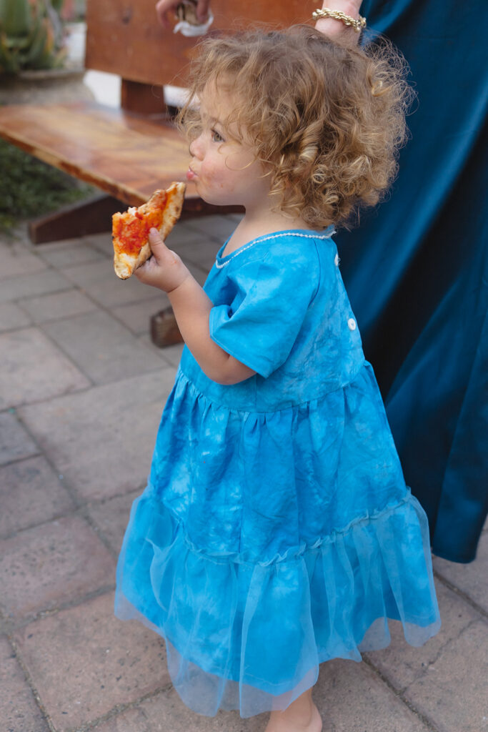 Little girl eating a slice of pizza