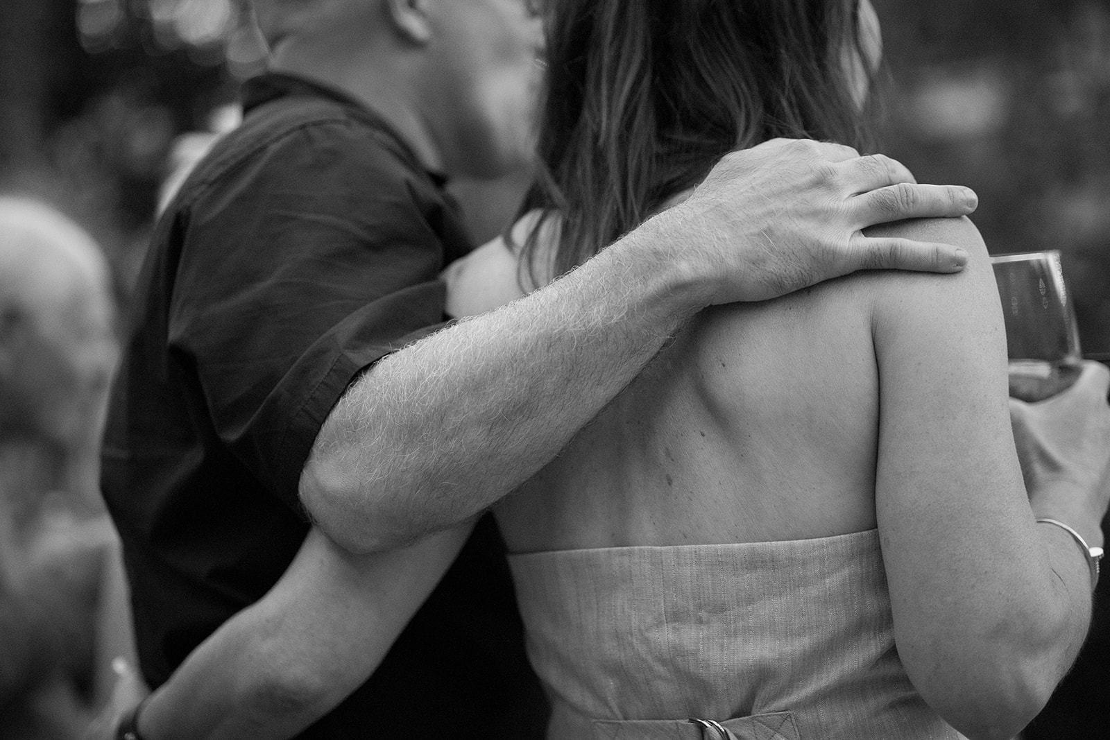 Black and white photo of a groom and bride embracing each other during speeches