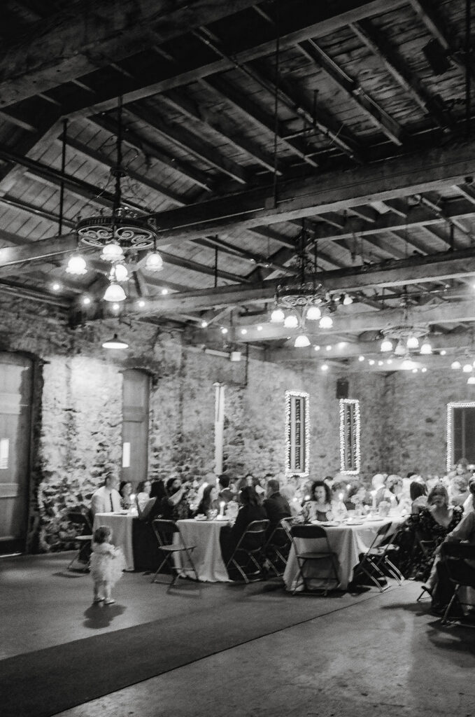 Black and white film photo of guests eating dinner during a reception at Miners Foundry in Nevada City, California.