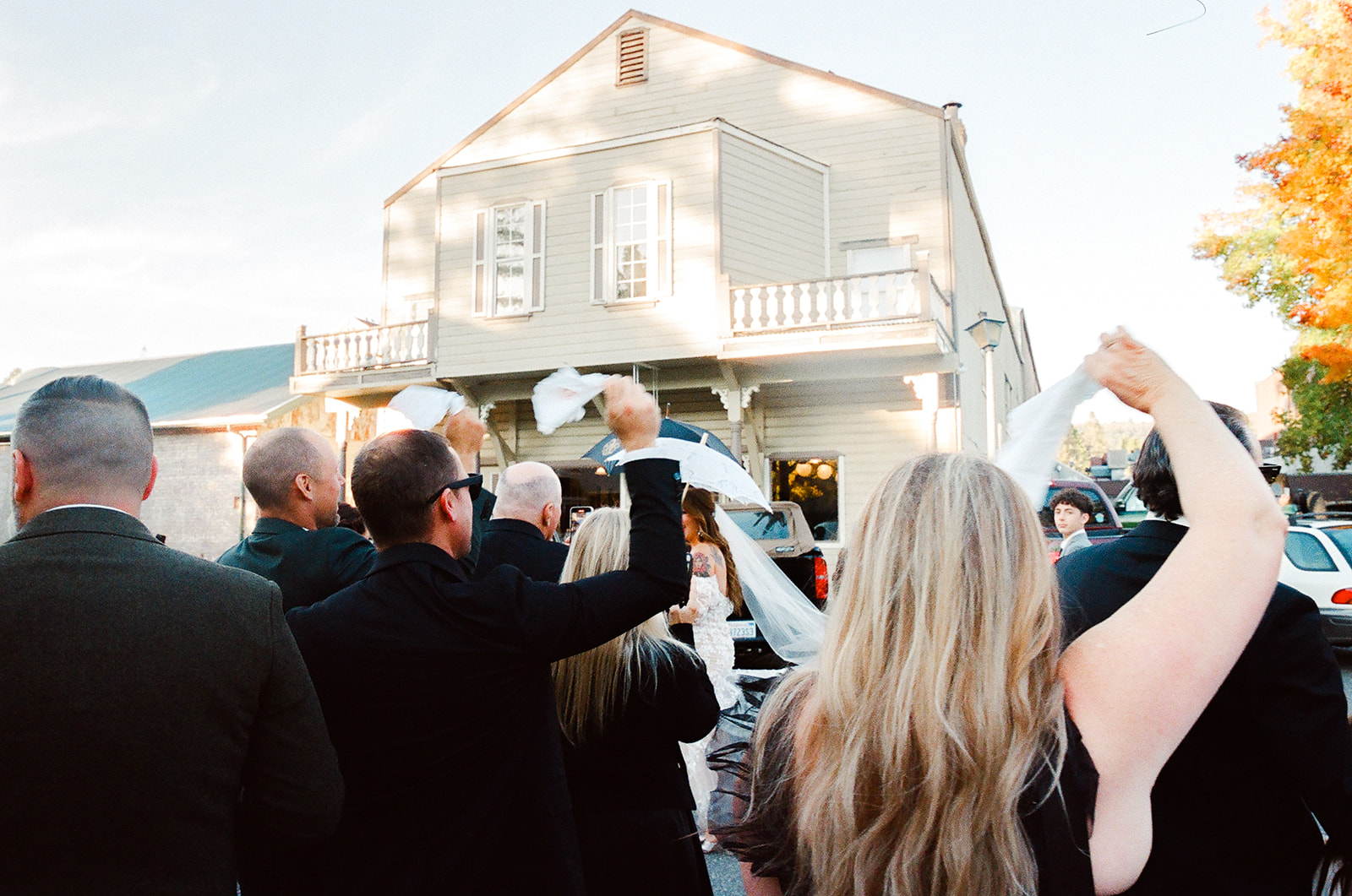 Wedding guests waving handkerchiefs during marching band processional in Nevada City