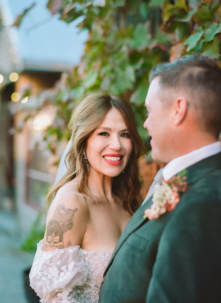 Bride smiling during couple portraits on film in downtown Nevada City wedding.