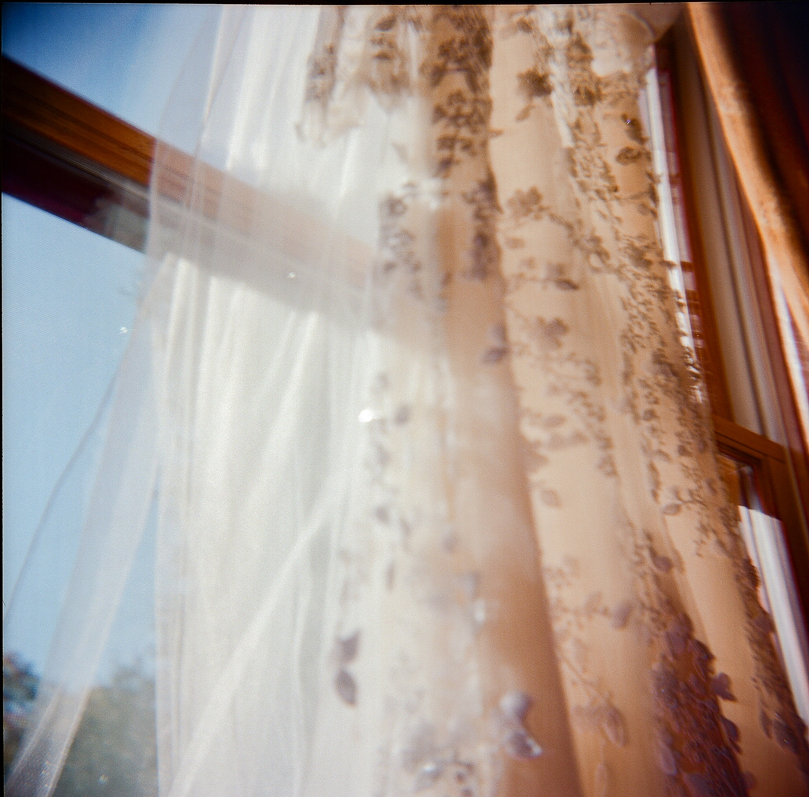 Wedding dress hanging in window light at getting ready location in Nevada City