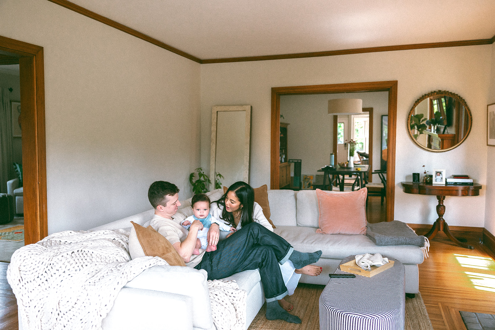 Family of three sitting on their couch during their at-home family photos in Oakland, California. 