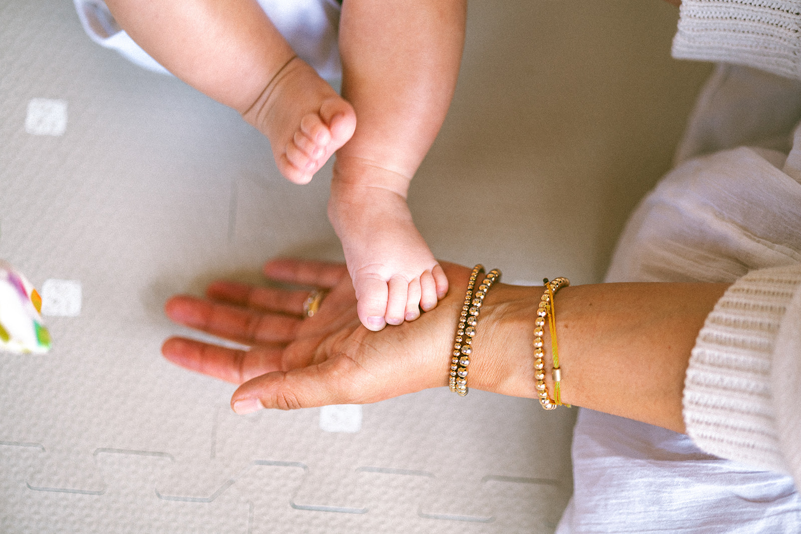 Close up photo of a mother holding her small babies feet.