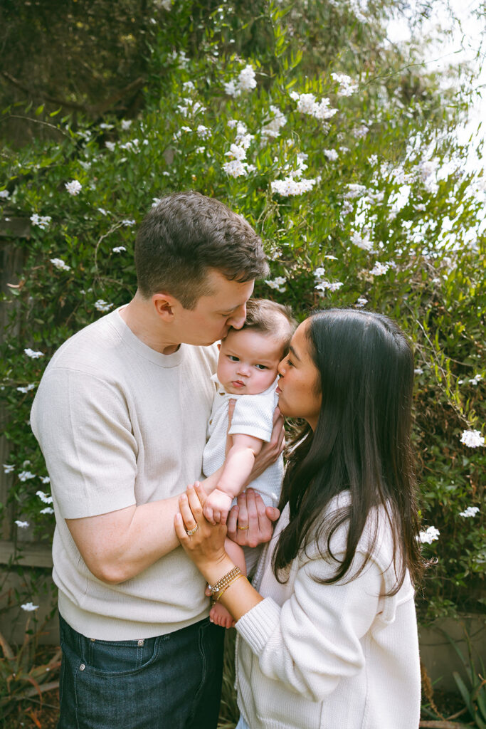 Mother and father kissing their baby during their at-home family photos in Oakland, California. 
