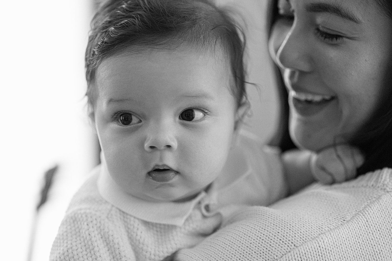 Close up black and white portrait of a mother holding her baby.