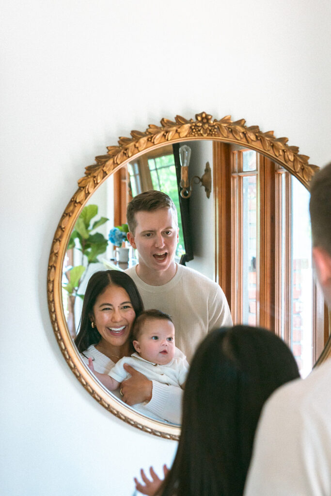 Family of three looking at themselves in a mirror during their at-home family photos in Oakland, California. 