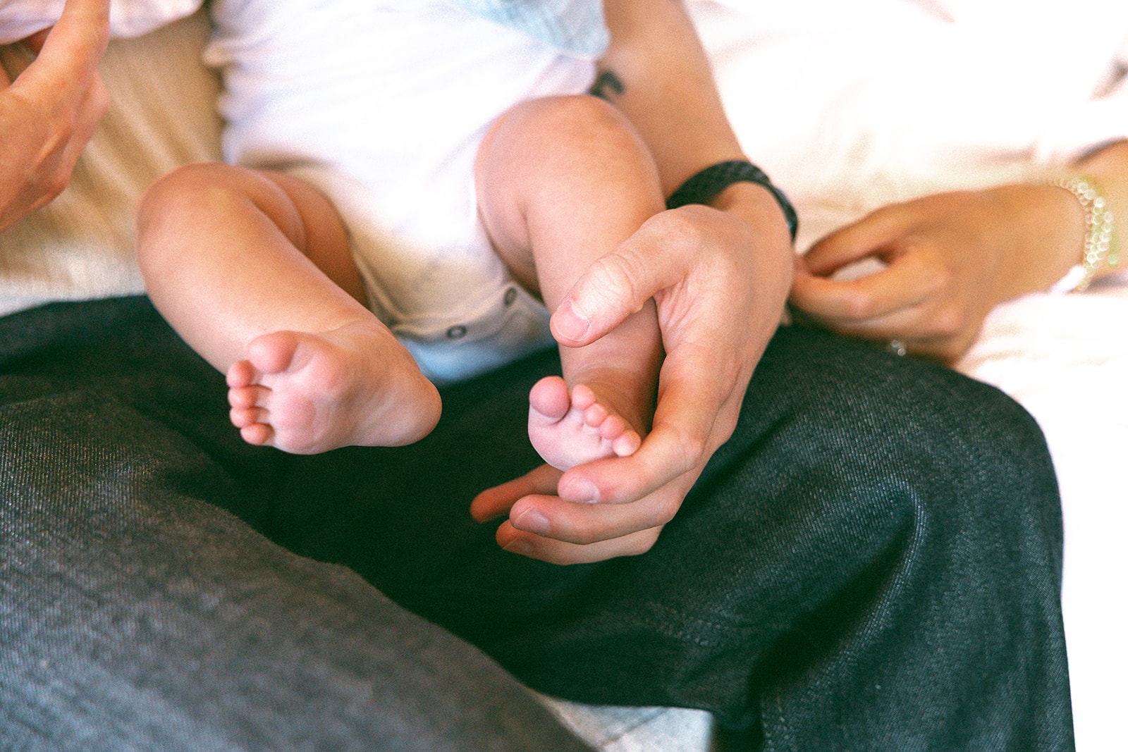 Close up shot of a mother and father holding their small baby.