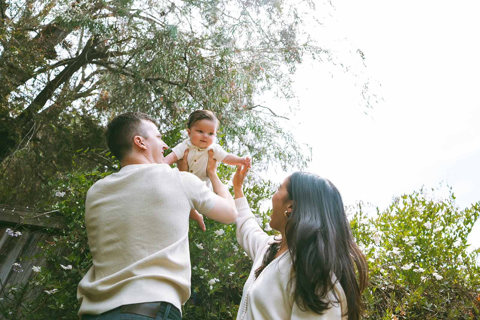 Family of three playing outdoors for their at-home family photos in Oakland, California.