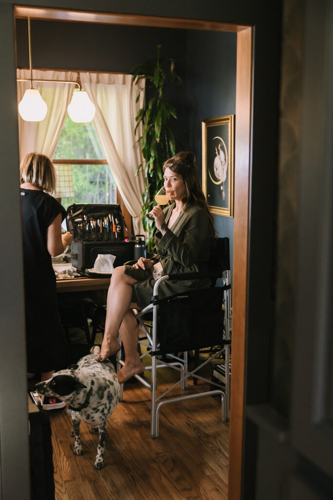 Bride sipping a mimosa while getting ready at inside of Moonrise on Mill Street Inn in Nevada City, California.
