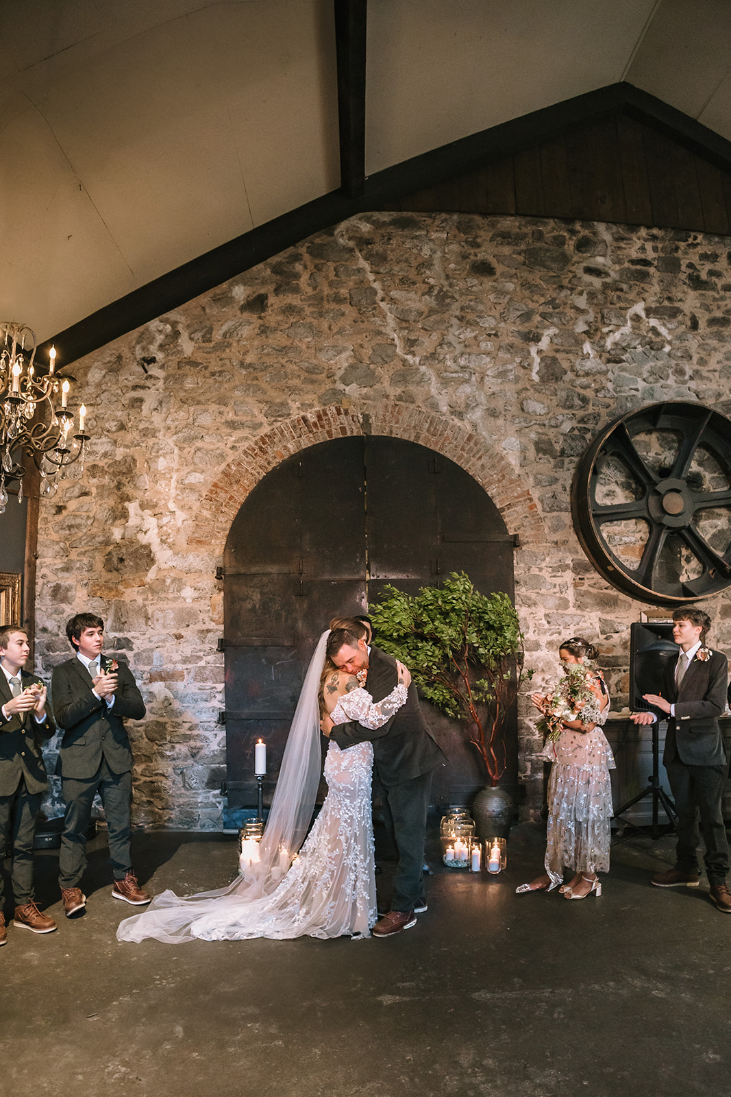 Bride and groom sharing their first kiss surrounded by family during Miners Foundry wedding ceremony in Nevada City, California.
